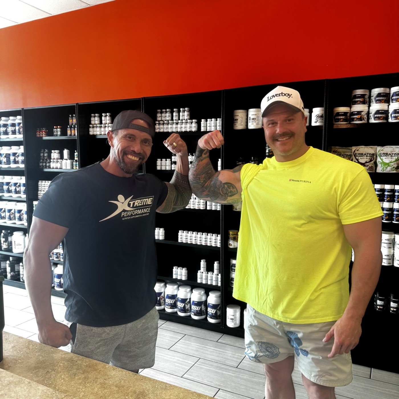 Coach L and a customer flexing at Xtreme Performance Nutrition