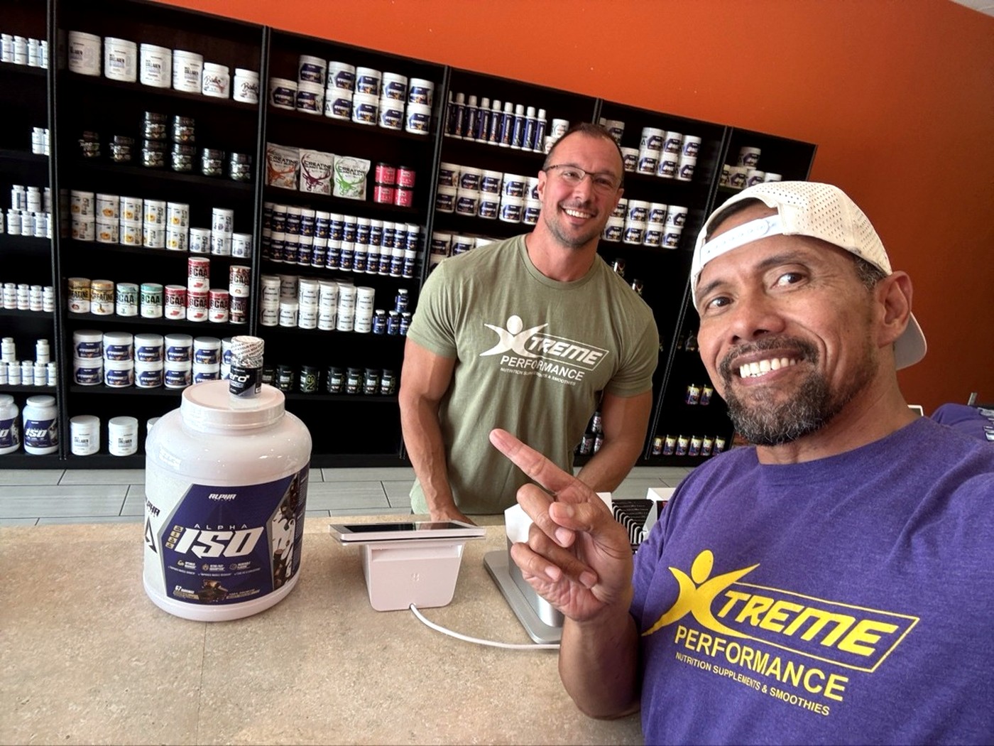 Coach L with Chase, a regular, at the Xtreme Performance Nutrition counter
